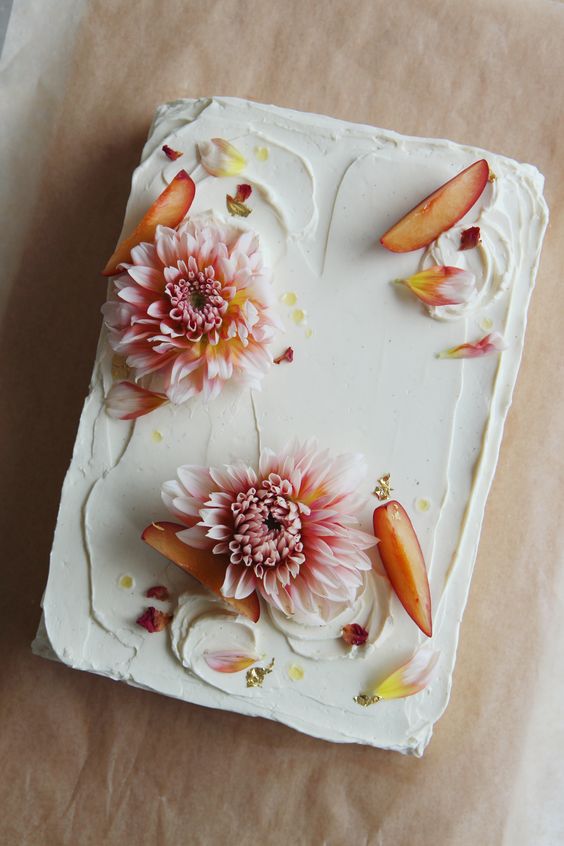 a small white sheet wedding cake topped with fresh blooms, petals and peaches is a cool idea for a small summer wedding