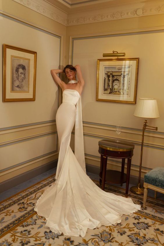 a strapless mermaid wedding dress with a train and a scarf are a super cool and chic combo for a modern wedding