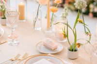 a subtle and delicate wedding tablescape with peachy and blush decor, cluster centerpieces and peachy candles