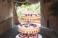 a tiered millefoglie wedding cake topped with fresh berries and a name topper is adorable for the summer