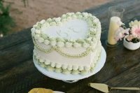 a white and green lambeth heart-shaped wedding cake is a lovely and trendy idea, with a coastal feel