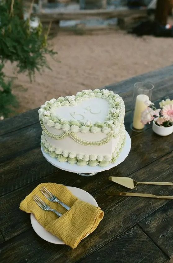 a white and green lambeth heart-shaped wedding cake is a lovely and trendy idea, with a coastal feel
