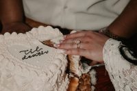 a white heart-shaped wedding cake with sugar details and some black calligraphy on top is a cool idea for a modern or vintage wedding