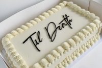 a white kitschy wedding cake topped with chocolate calligraphy is a lovely idea for a modern wedding with an edge