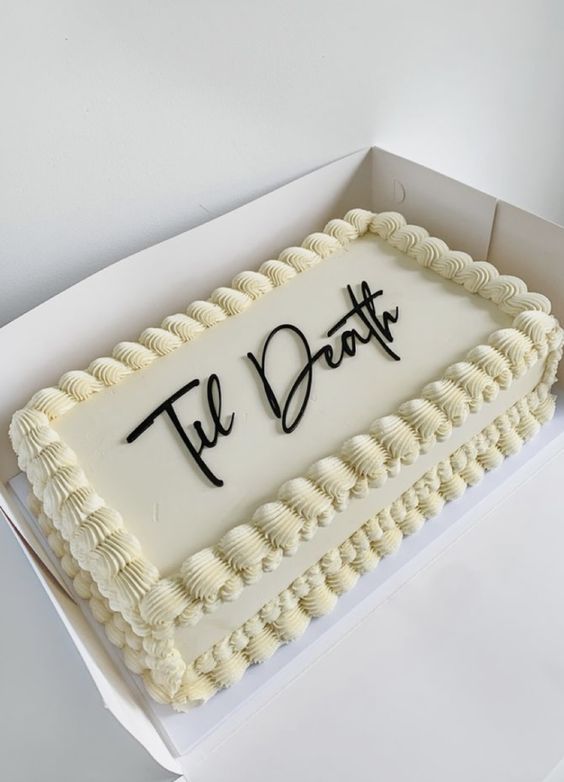 a white kitschy wedding cake topped with chocolate calligraphy is a lovely idea for a modern wedding with an edge