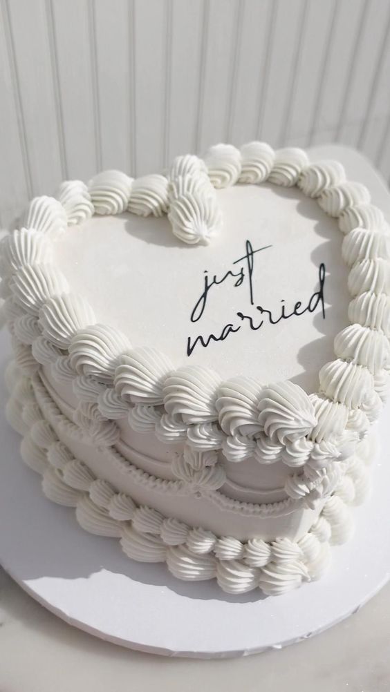a white lambeth wedding cake with sugar detailing and black calligraphy is a cool idea for a modern wedding