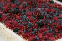 a white sheet wedding cake topped with lots of fresh berries is a delicious dessert for a summer wedding