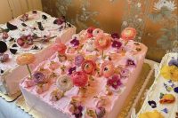 an assortment of sheet wedding cakes topped with fresh bright blooms is a cool idea for a spring or summer wedding