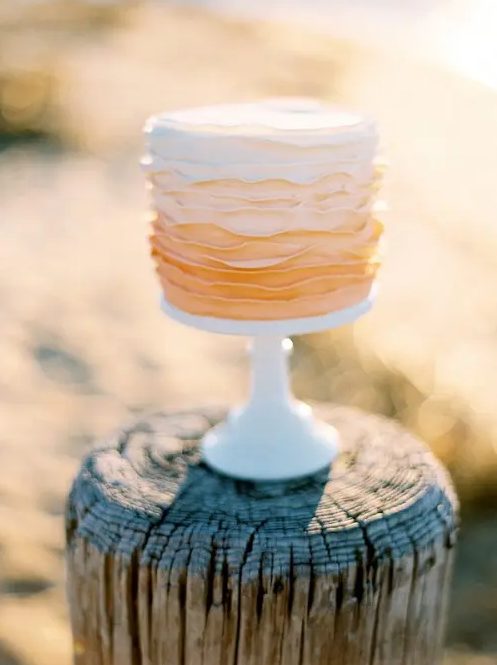 an ombre ruffle wedding cake from white to peachy pink is a beautiful idea for a spring or summer wedding