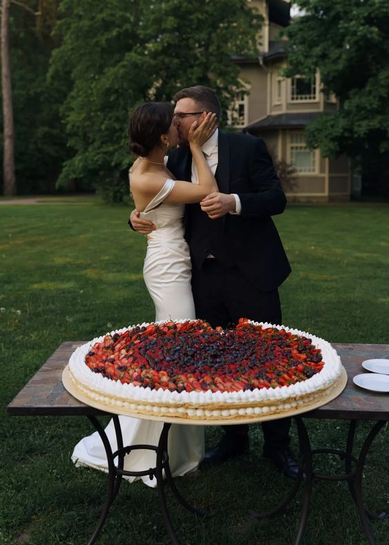 an oversized round millefoglie wedding cake topped with meringues and fresh berries and fruit is amazing for a summer wedding