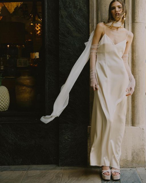 an ultra-modern bridal look with a silk maxi slip wedding dress, platform shoes, sheer gloves and a scarf plus statement earrings