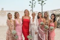 bridesmaid wearing pink floral midi and maxi dresses and the maid of honr rocking a deep red maxi dress