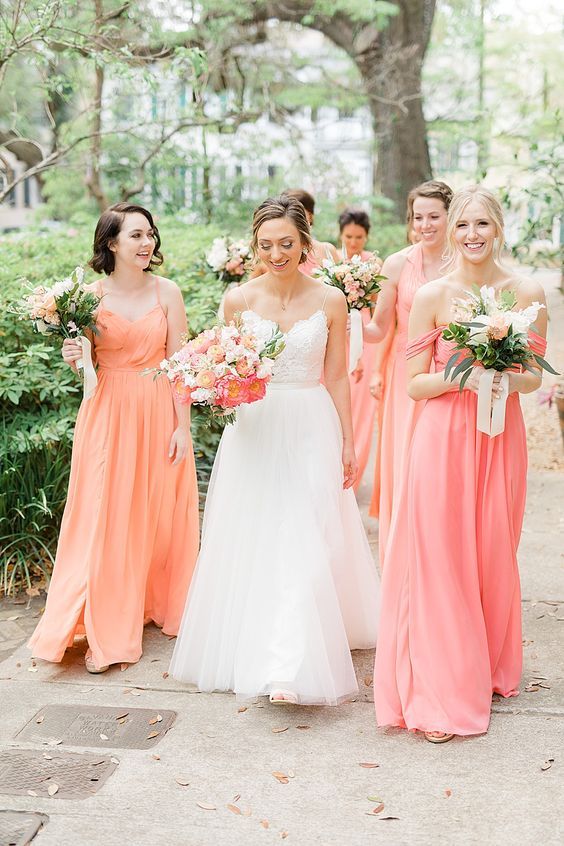 coral, orange and peachy pink maxi bridesmaid dresses of mismatching designs and with draped skirts are great