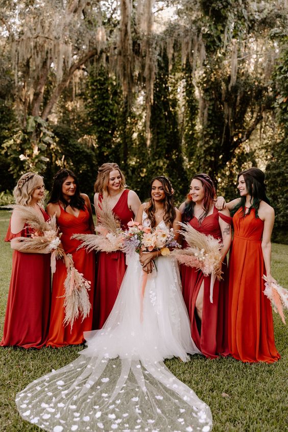 fantastic bold red maxi bridesmaid gowns with draping are amazing for a bright fall boho wedding