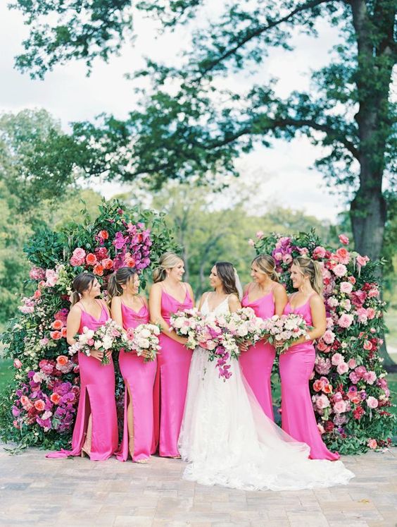 Hot pink slip bridesmaid dresses with slits and trains are a great idea for a pink infused summer or garden wedding