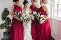 lovely deep red one shoulder A-line maxi bridesmaid dresses with draped bodices and skirts for a Christmas wedding