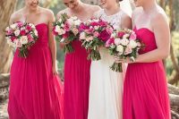 lovely strapless A-line hot pink bridesmaid maxi dresses with draped bodices and pleated skirts are great for a lovely bold wedding
