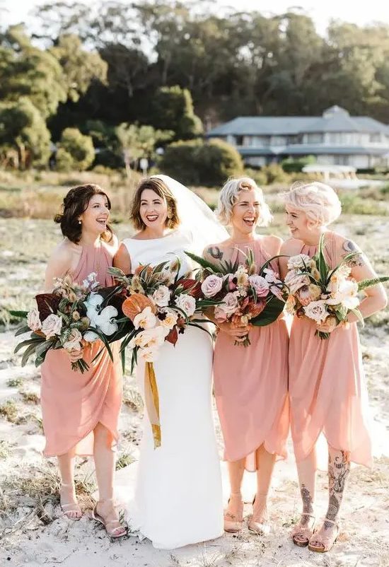 matching light pink midi wrap bridesmaid dresses with drapery and comfy sandals for a tropical wedding