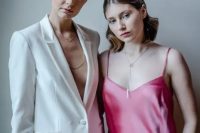 one bride wearing a white pantsuit, the other bride rocking a hot pink slip wedding dress are a fantastic and out of the box idea for a modern wedding