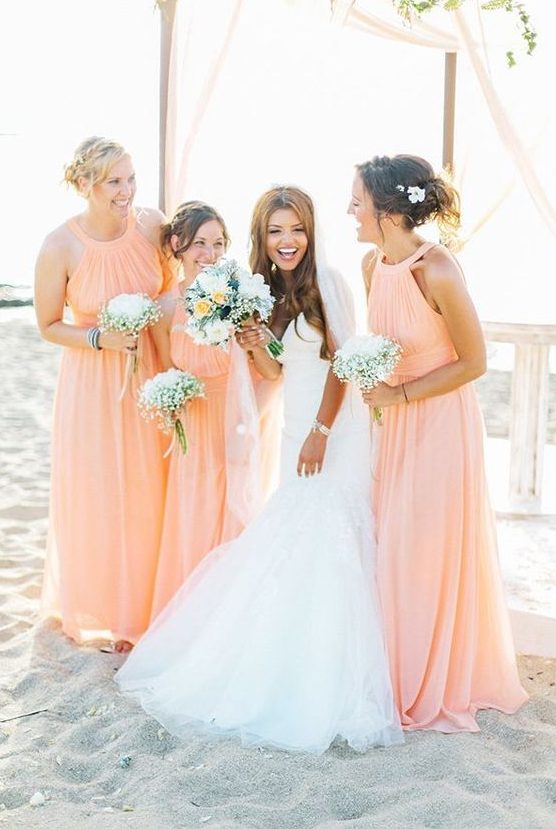 pretty halter neckline peachy pink maxi bridesmaid dresses with criss cross sashes and pleated bodices for a beach wedding