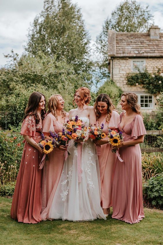 pretty mix and match pink maxi bridesmaid dresses with short sleeves and pleated skirts for a summer garden wedding