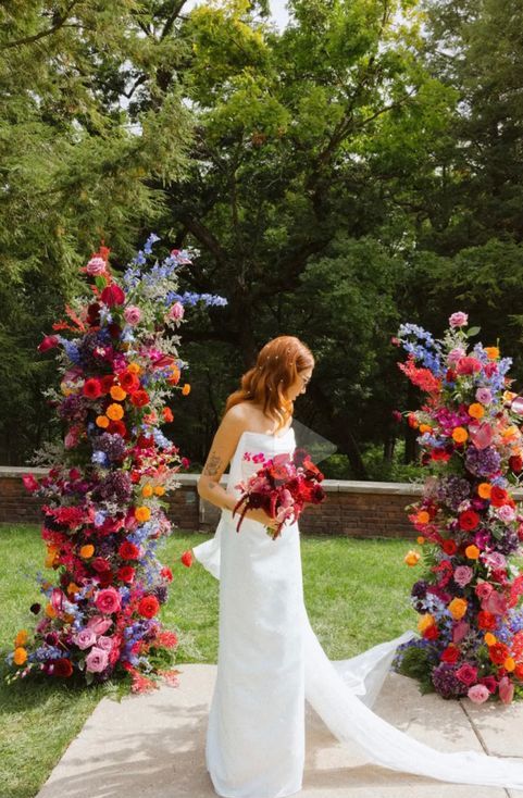 a bold wedding altar of orange, red, violet, pink and blue blooms and some greenery is a fantastic idea for the summer