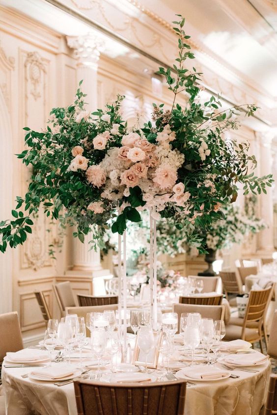 a bold tall wedding centerpiece of white and blush roses and dahlias and lots of greenery is amazing