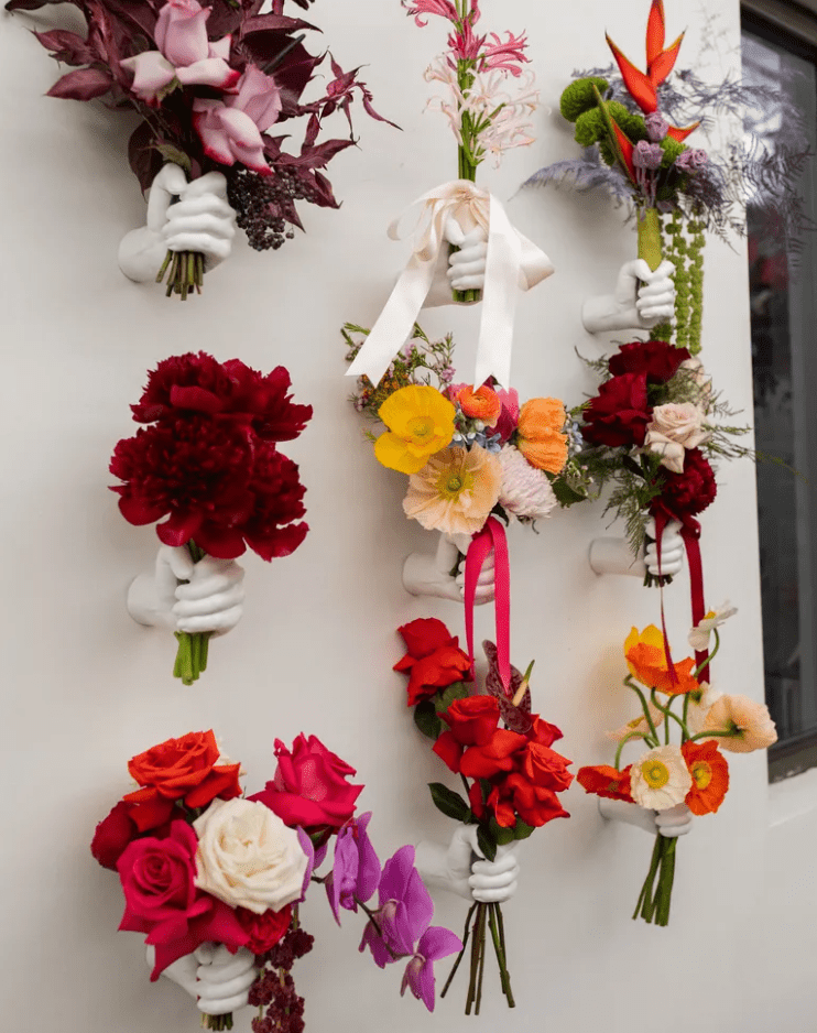 a bold floral wedding installation with a whole arrangement of bright floral bouquets is amazing and cool