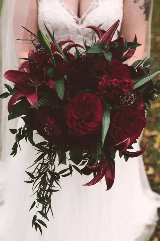 a Halloween wedding bouquet with pink, red and burgundy blooms, greenery and foliage is a colorful statement