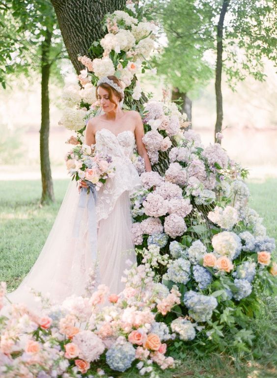 a beautiful living tree wedding altar with white, pale pink and blue hydrangeas and peachy roses is amazing for spring or summer