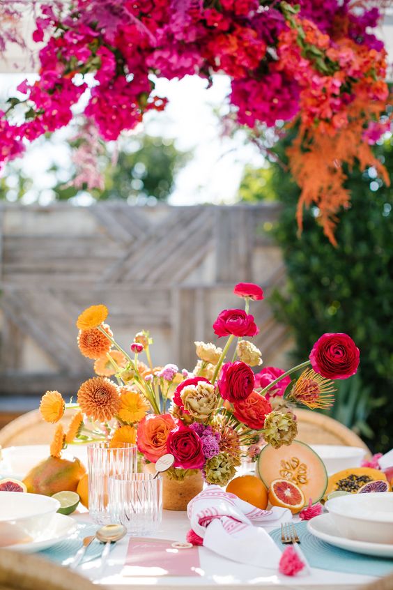 a bright summer wedding centerpiece of yellow, orange, hot pink and red blooms is a cool idea for a tropical wedding