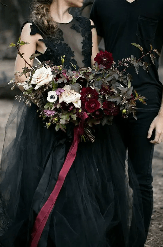 a chic wedding bouquet with dark foliage, deep red and blush blooms plus burgundy ribbons