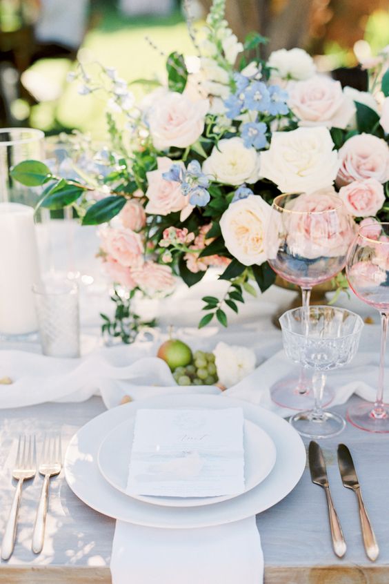 a classic pastel wedding centerpiece of blush, serenity blue and neutral blooms and greenery is perfect for a garden wedding