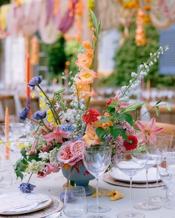 a colorful wedding centerpiece of pink, orange, purple, red and blush blooms and greenery is amazing