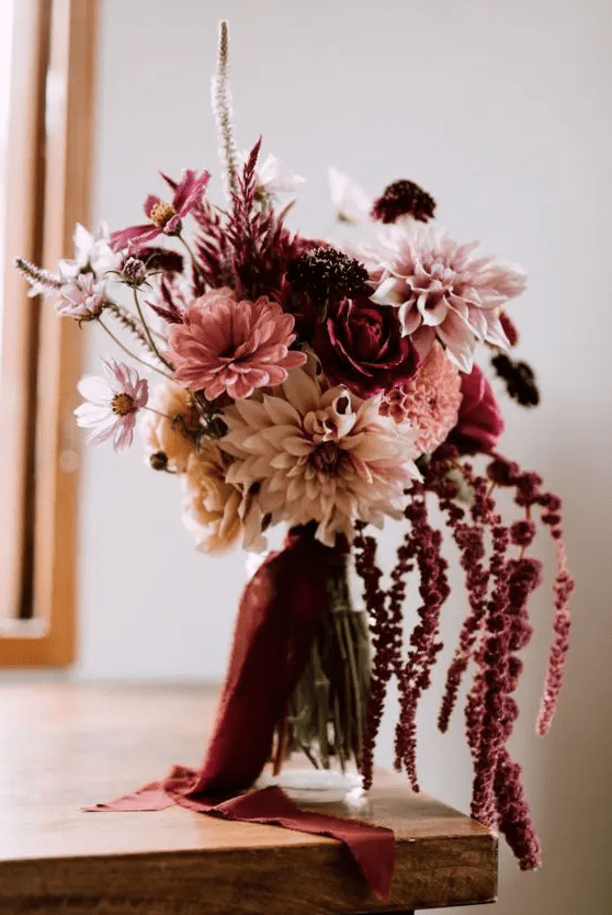 A contrasting wedding bouquet of blush and pink blooms plus mauve and burgundy ones and amaranthus for an eye catching element