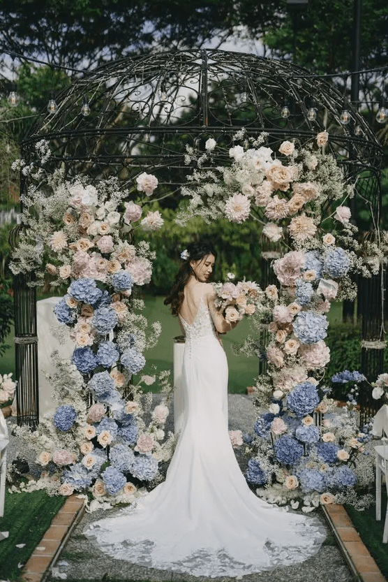 a creative wedding arch made using a rotonda and blush and blue hydnrageas, roses and dahlias looks very delicate and chic