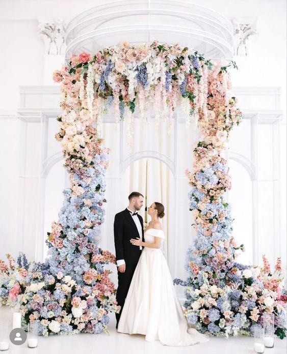 a fantastic wedding altar done with blue hdyrangeas, blush and white roses and some periwinkle blooms is jaw-dropping