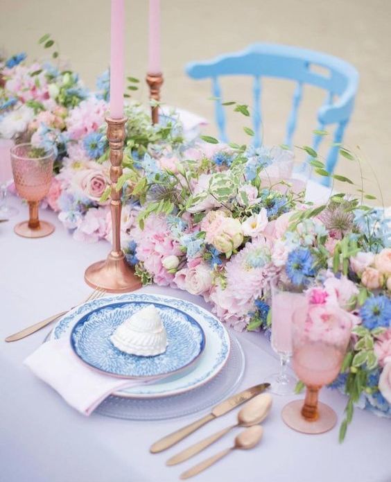 a lovely lush wedding centerpiece of pastel pink, blue flowers, greenery and twigs is a cool idea