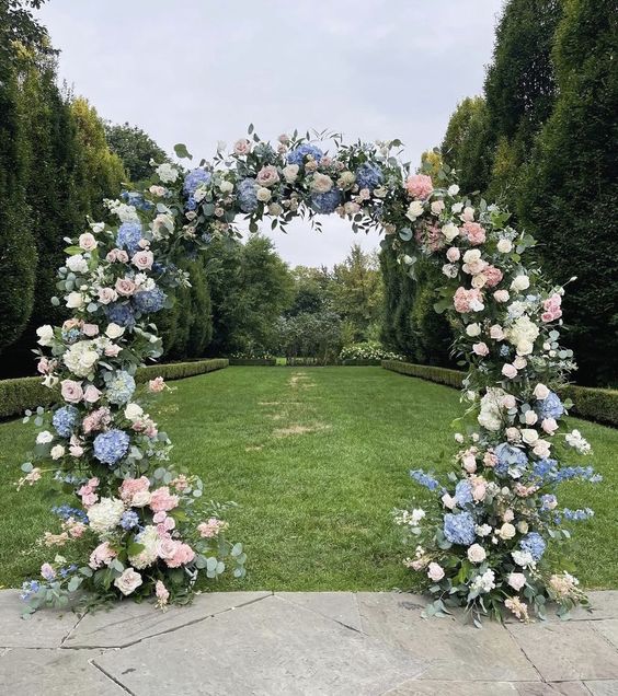 a lovely round wedding arch with blush roses and white and blue hydrangeas is a chic and elegant idea for a spring wedding