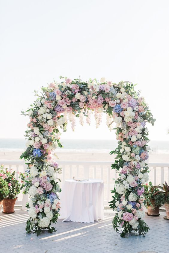 a lovely spring wedding arch done with white and pastel blooms and greenery is classics for spring