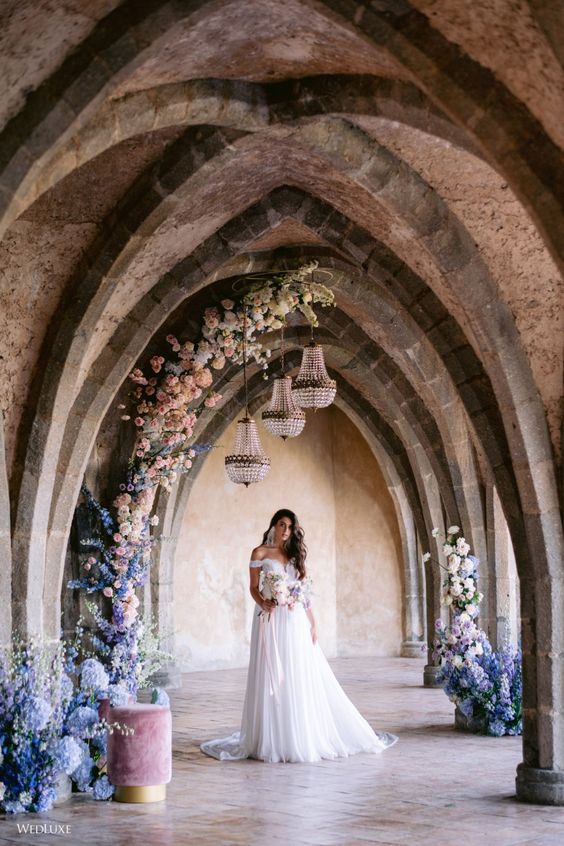 a pastel wedding altar covering the arched corridor looks amazing, blue, pink and lilac blooms make it very lively