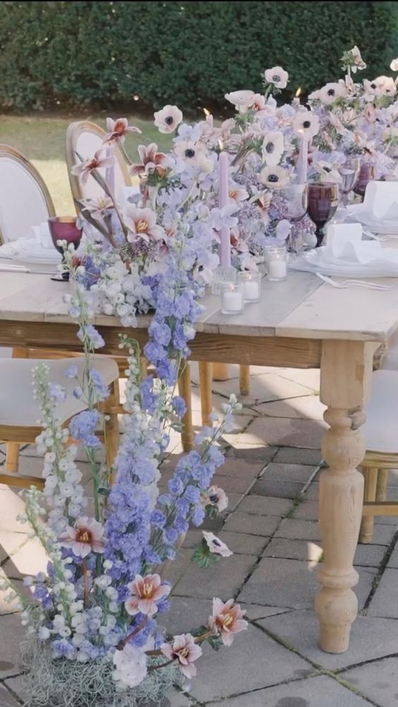 a pastel wedding centerpiece of blue, lilac and white flowers is a stylish idea for a garden wedding