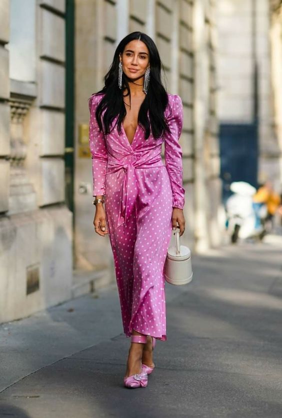 a pink polka dot jumpsuit with a knotted detail, hot pink shoes and statement earrings plus a bucket bag for a shower or a wedding