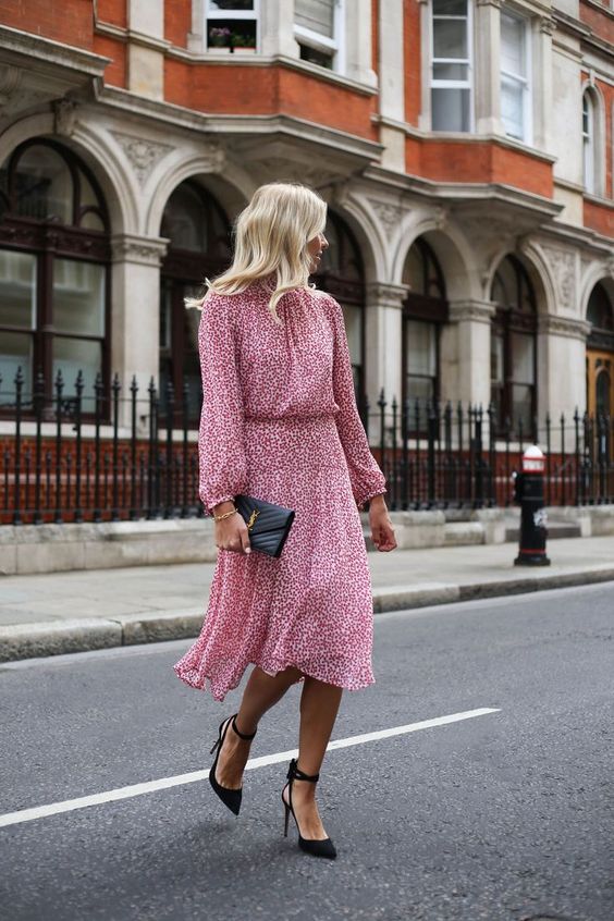 a pink printed midi dress with a high neckline, long sleeves, black lace up shoes and a small black clutch for a bridal shower