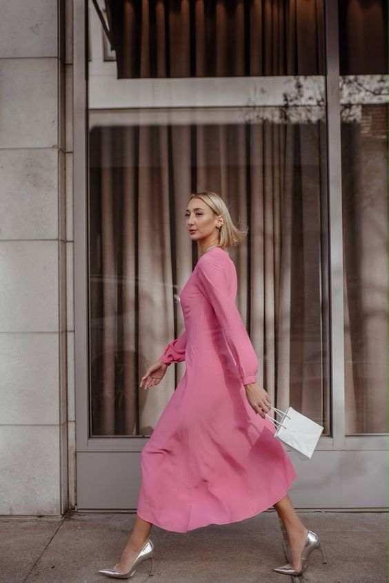 a plain pink midi dress with long sleeves, silver heels and a small white bag for a chic spring bridal shower look