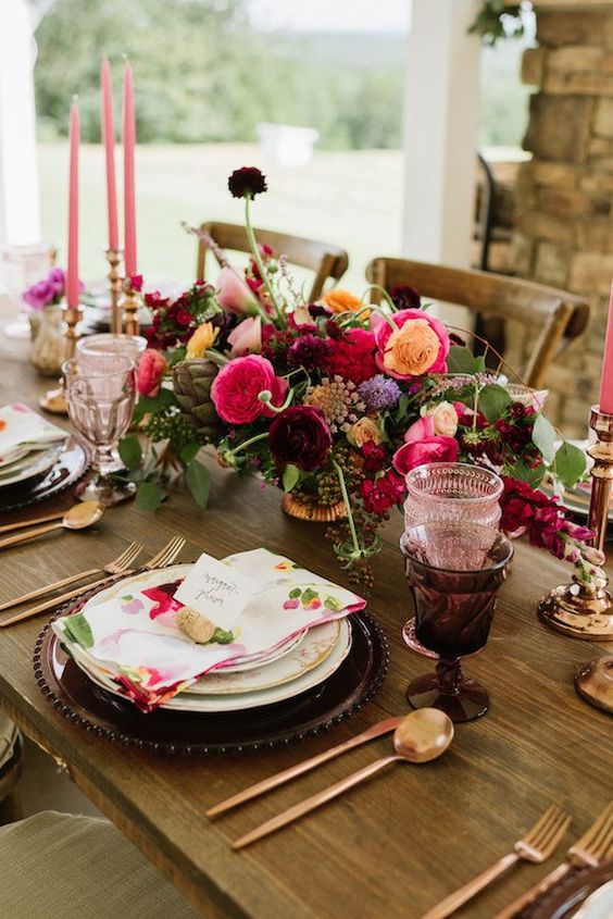 a refined and bold fall wedding centerpiece of hot pink, yellow, deep purple and lilac blooms and greenery