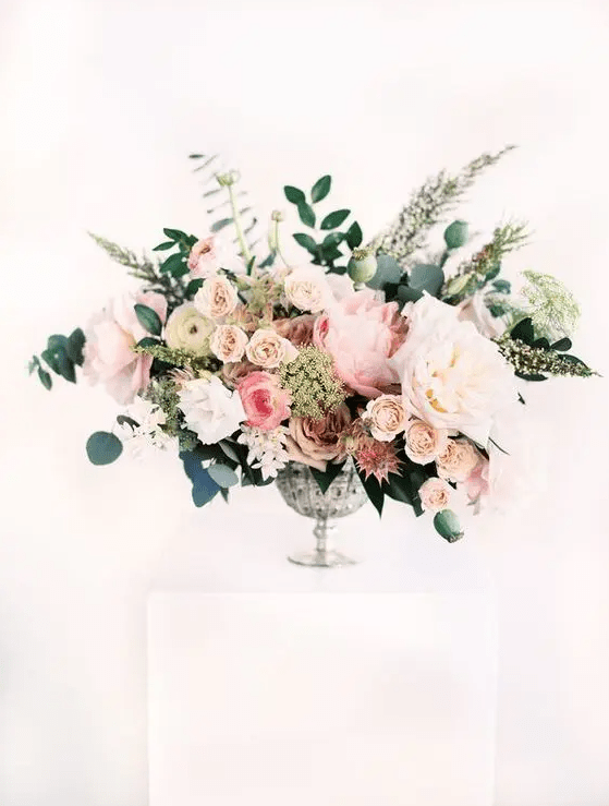 a super lush and textural floral centerpiece with blush, pink and white blooms, herbs and greenery