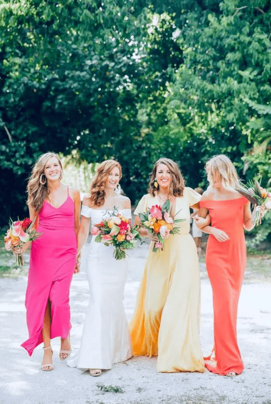 bright mismatching bridesmaid dresses, a coral, yellow and hot pink one, are a great idea for a summer wedding