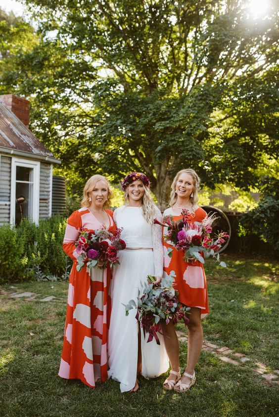 colorful orange and pink knee and maxi bridesmaid dresses are a fun idea for a bright summer wedding