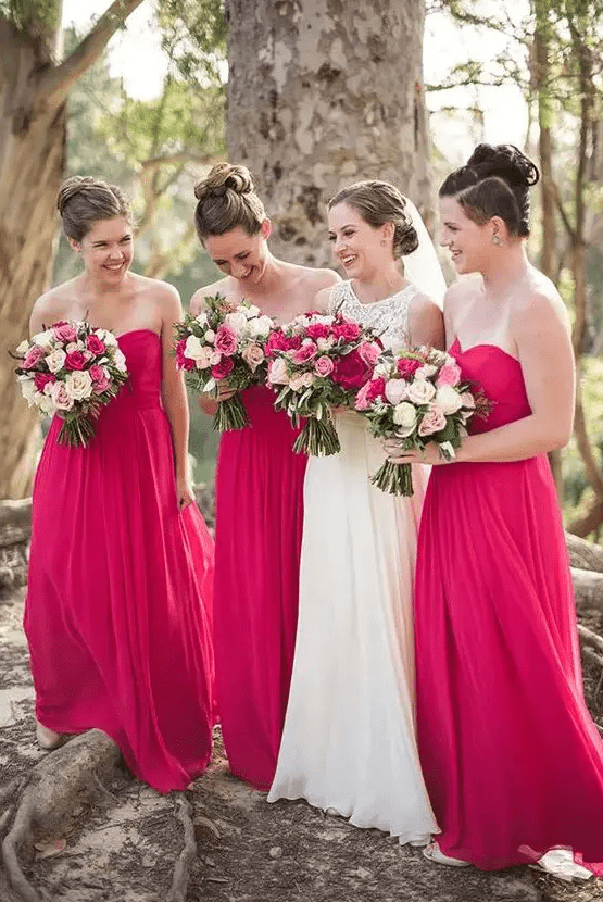 Lovely strapless A line hot pink bridesmaid maxi dresses with draped bodices and pleated skirts are great for a lovely bold wedding